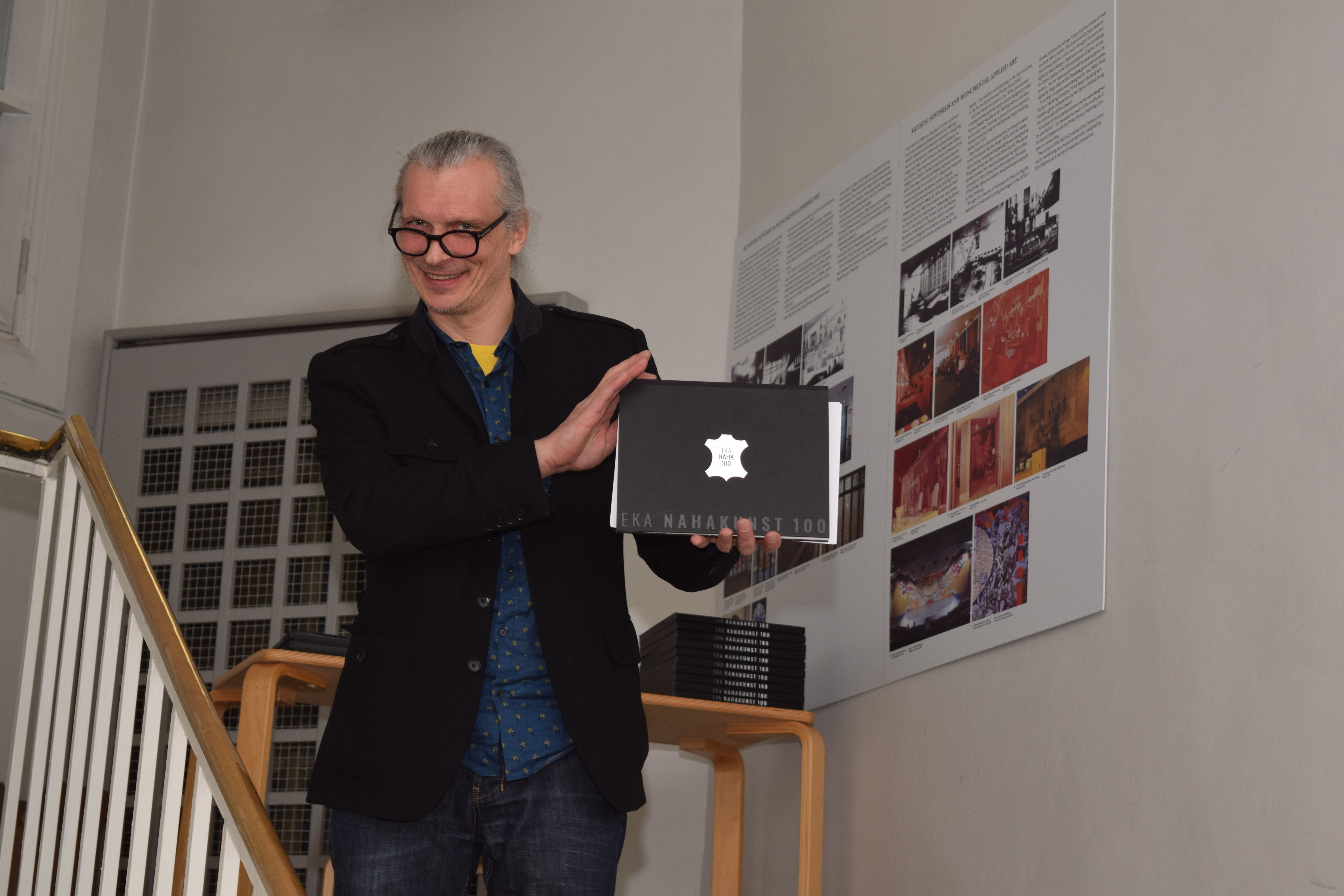 Photo by Eva Luure. Lennart Mänd, Professor of Leather Art, showing off the anniversary publication