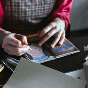 A student illustrating and coloring in a page.
